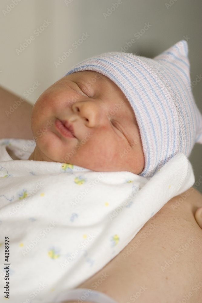 母亲手臂上的新生男婴儿童面部特写