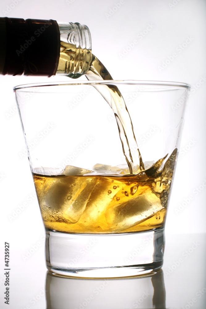 威士忌被倒入白底玻璃杯中