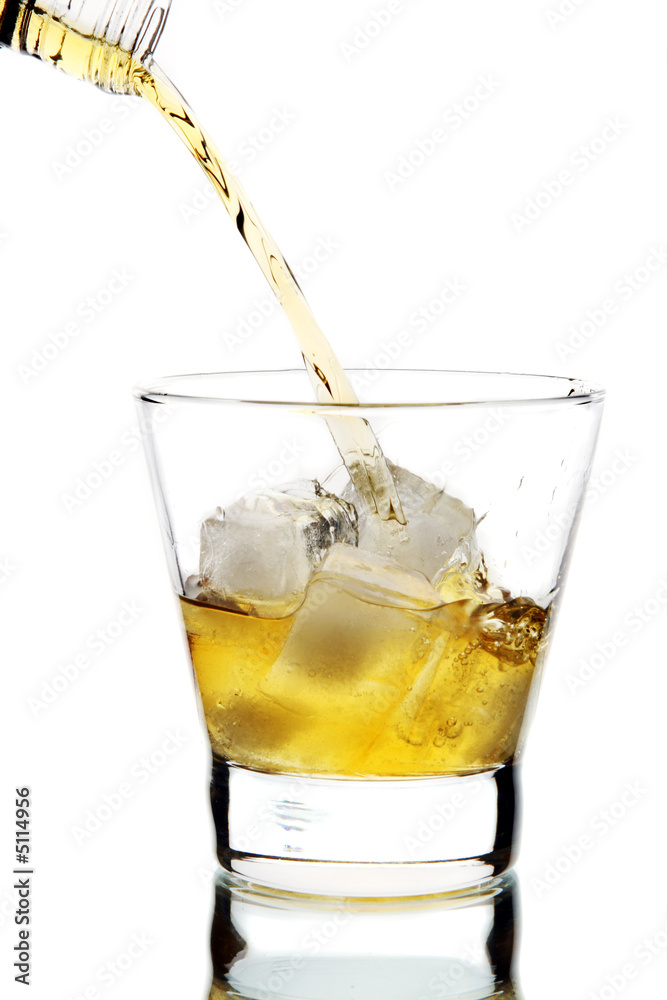 将威士忌倒入玻璃杯中（在白色背景上隔离）