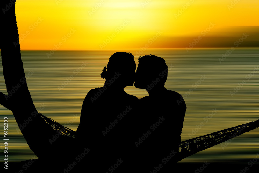 日落时亲吻情侣的剪影。