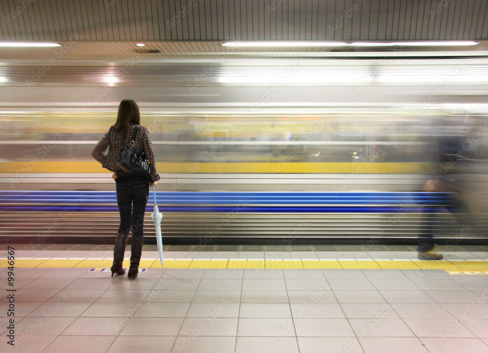 一个孤独的女人看着地铁飞驰而过。