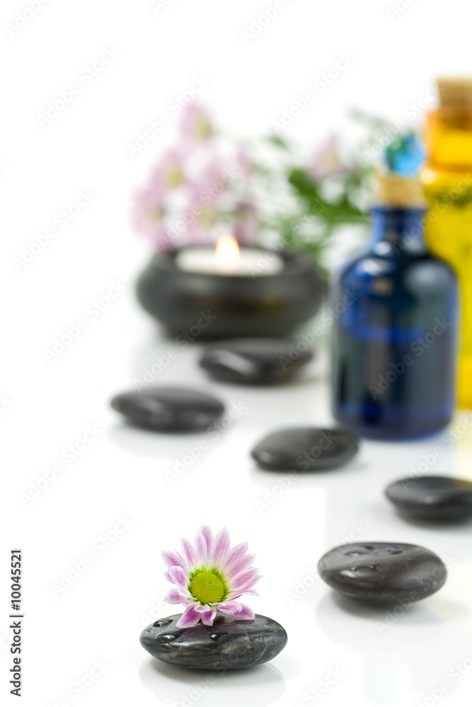 Pebbles, candle, essential oils and flowers. Selective focus