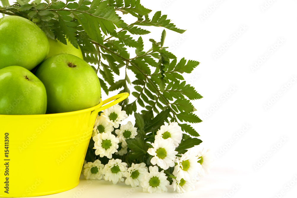 绿色苹果、黄色水桶和花朵
