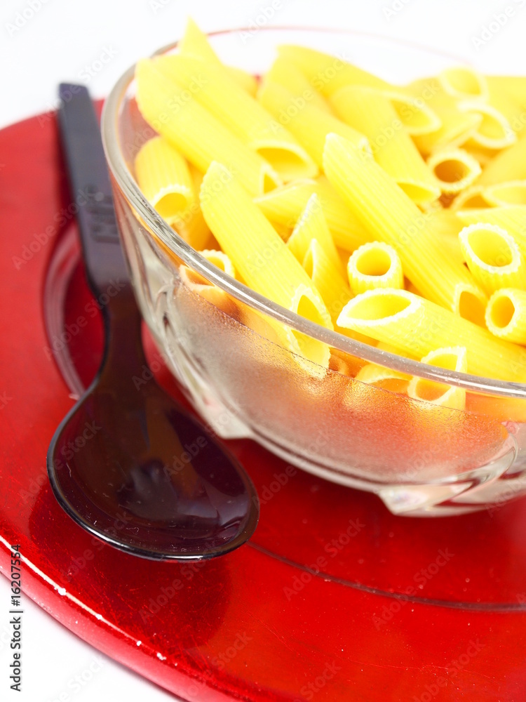 Uncooked pasta served in saucer on red plate