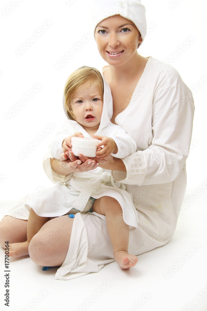 幸福的妈妈抱着婴儿的化妆品霜的照片