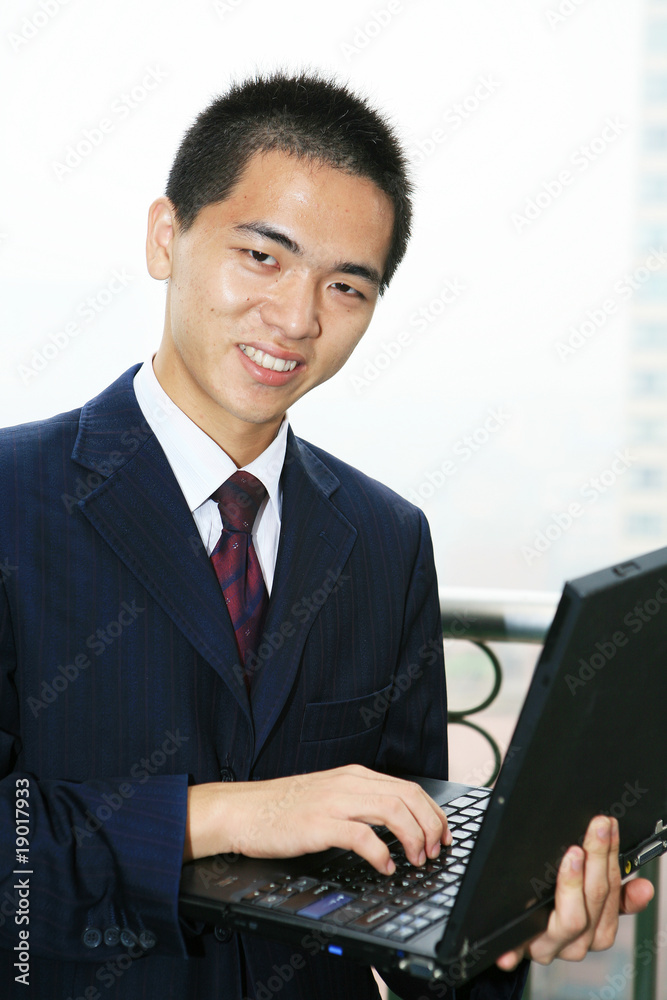 young asian businessman work with laptop on the balcony