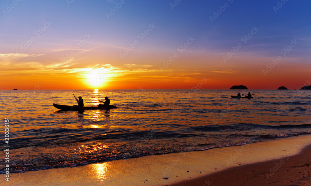 日落时有皮划艇运动员的海景
