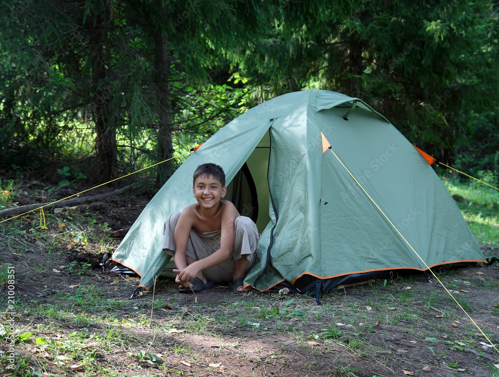 露营帐篷附近的快乐男孩