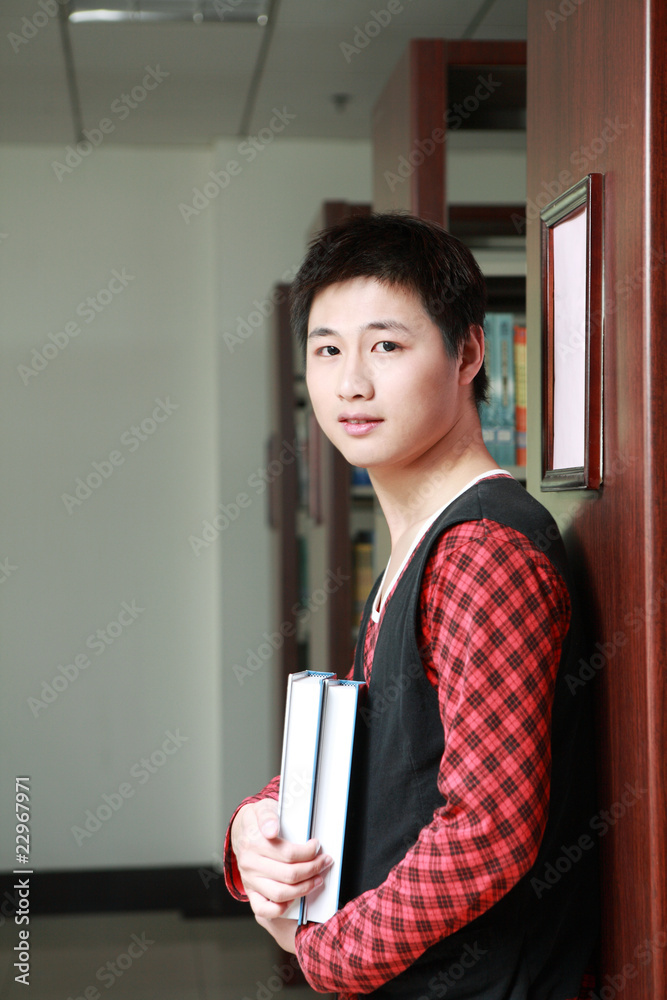 亚洲男孩在图书馆学习