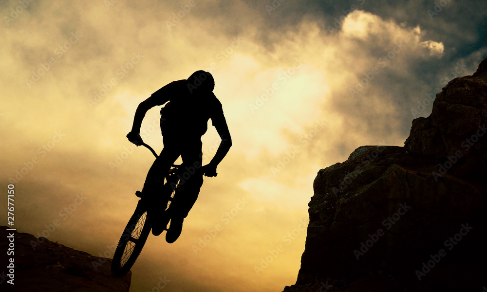 日落时分，一个骑着蒙丹自行车的男人的剪影