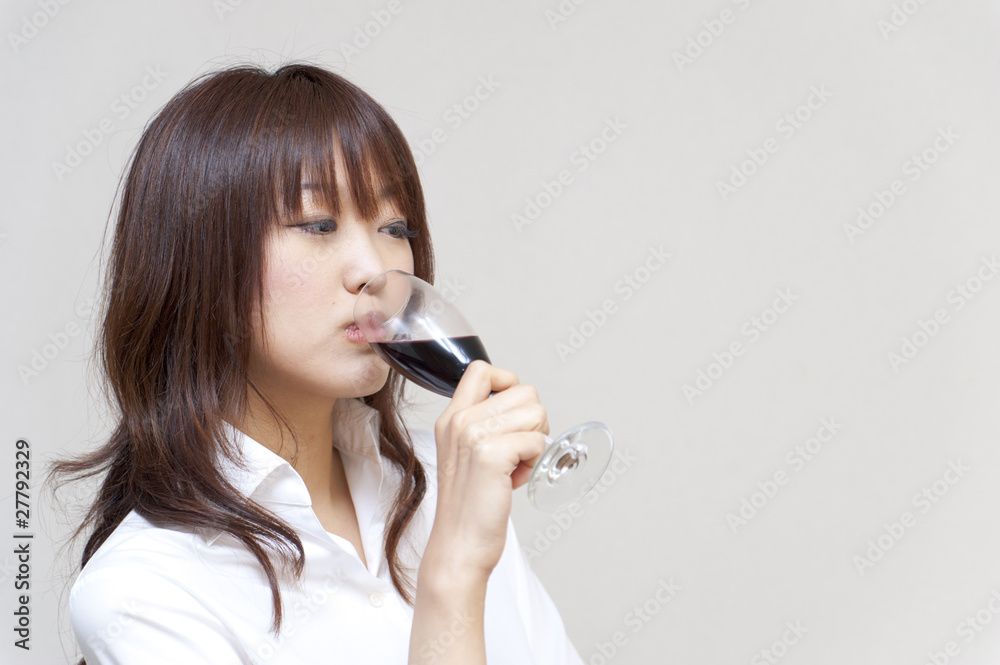 a portrait of  young woman taking a red wine