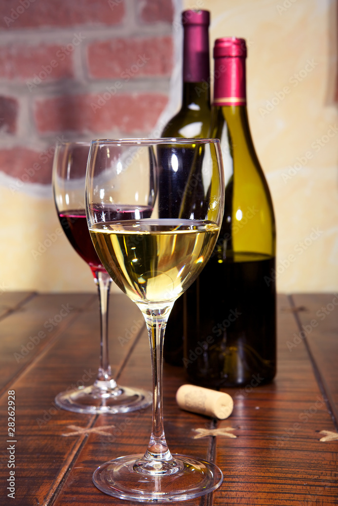 一杯白葡萄酒、一杯红葡萄酒和桌子上的瓶子