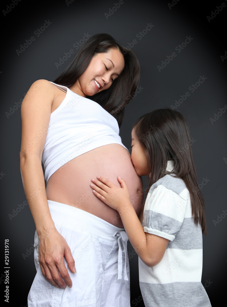 女孩亲吻婴儿怀孕