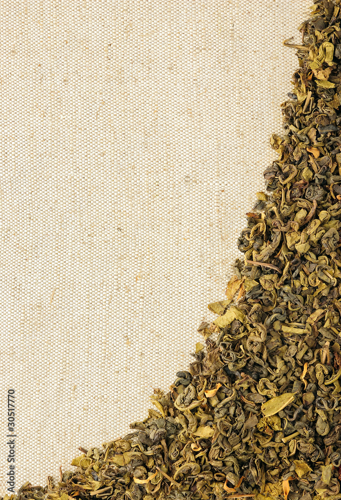 麻布上的干绿茶叶子，垂直背景