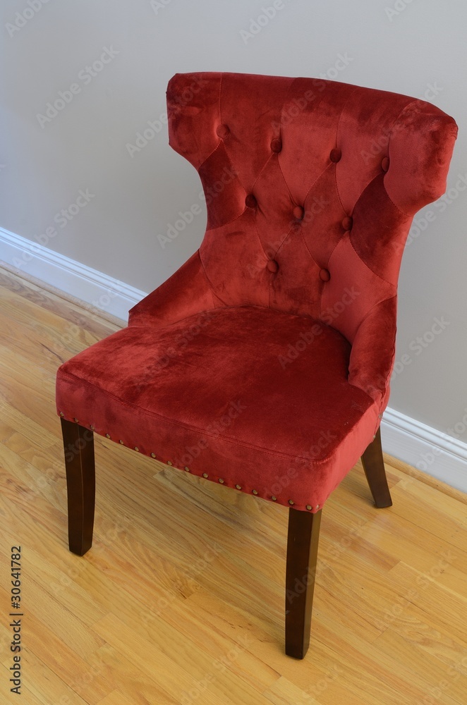 硬木地板上的毛绒红色椅子