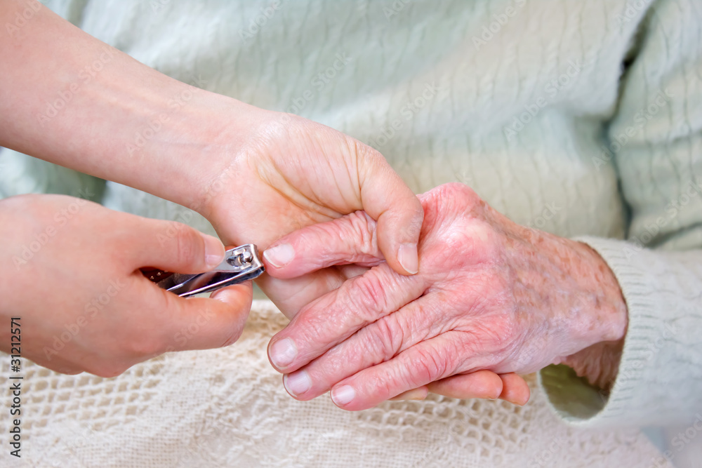 帮助老年妇女剪指甲