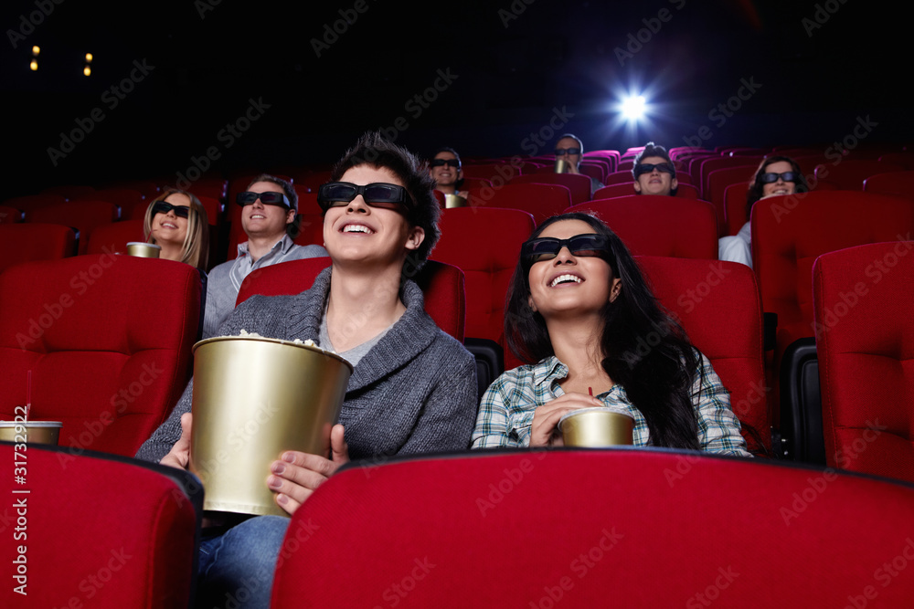 有趣的人在电影院里戴着3D眼镜看电影