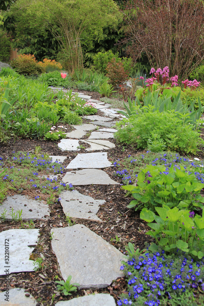 春天花园里美丽的铺石人行道。