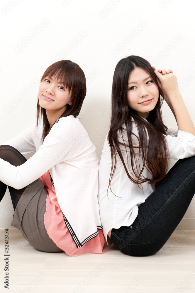 两个亚洲女孩坐在客厅里