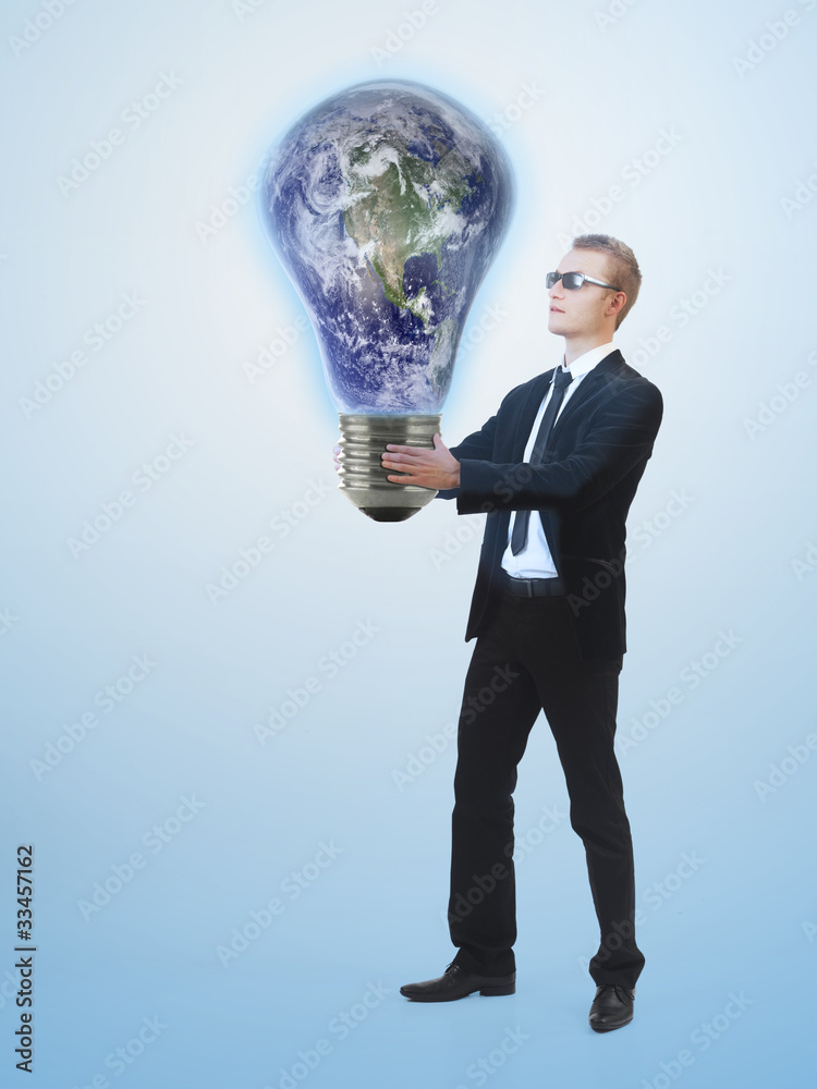 Young business man holding a huge lightbulb