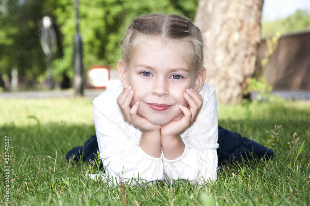 年轻女孩躺在绿草上微笑