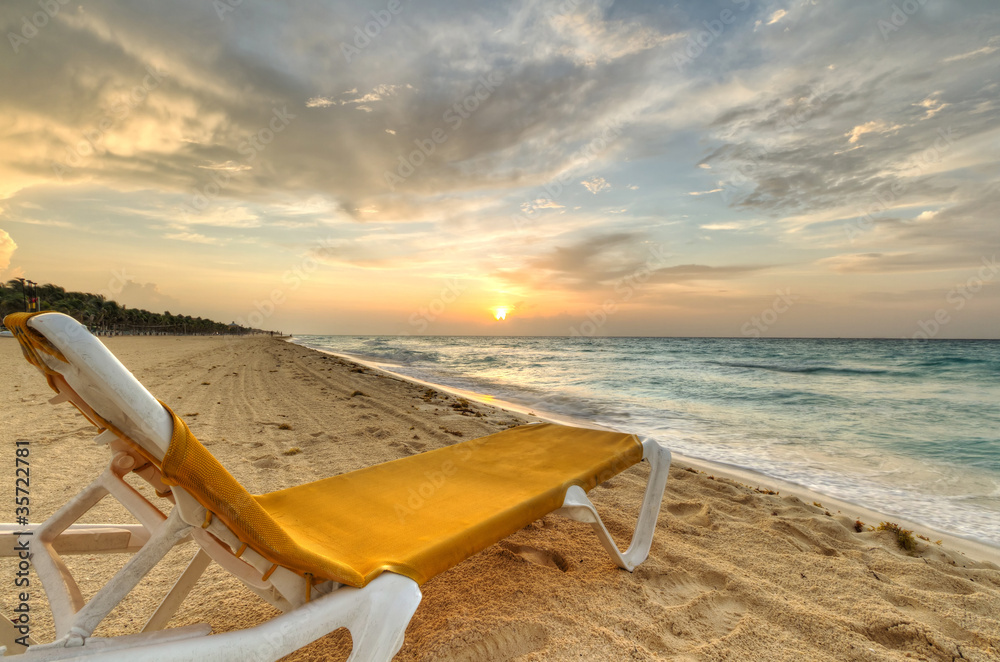 日出时加勒比海上的空躺椅
