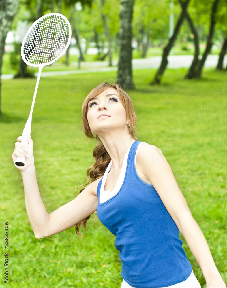 美丽的年轻女子拿着羽毛球球拍