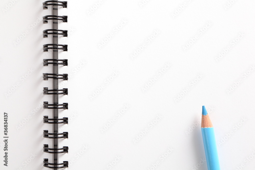 notebook and blue pencil on white background