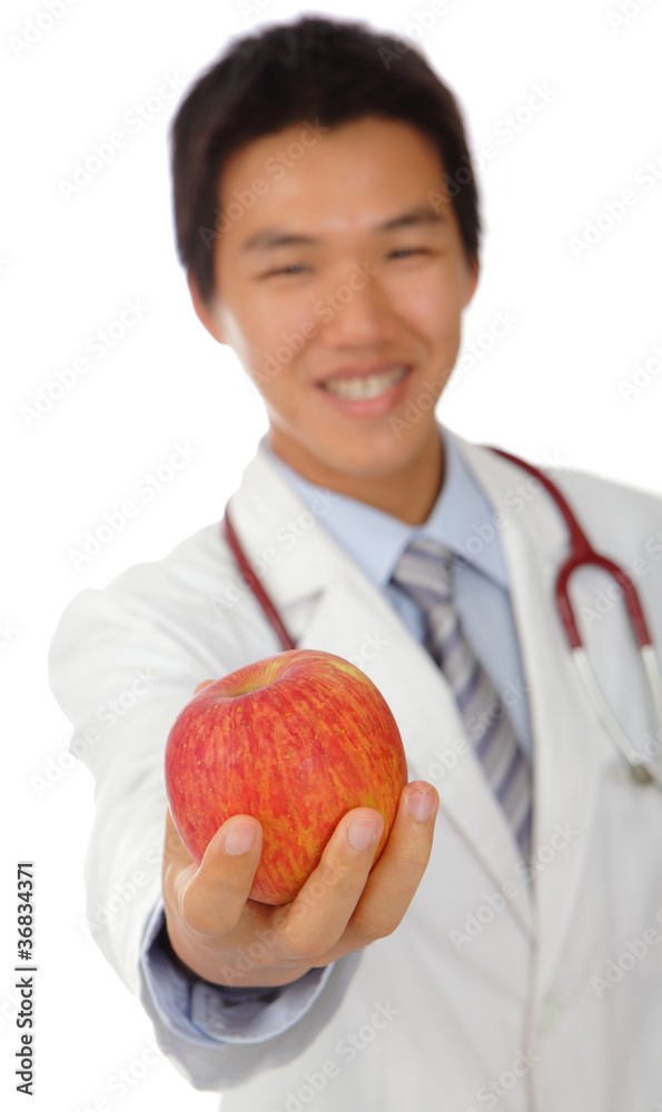 年轻的医生微笑着拿着苹果