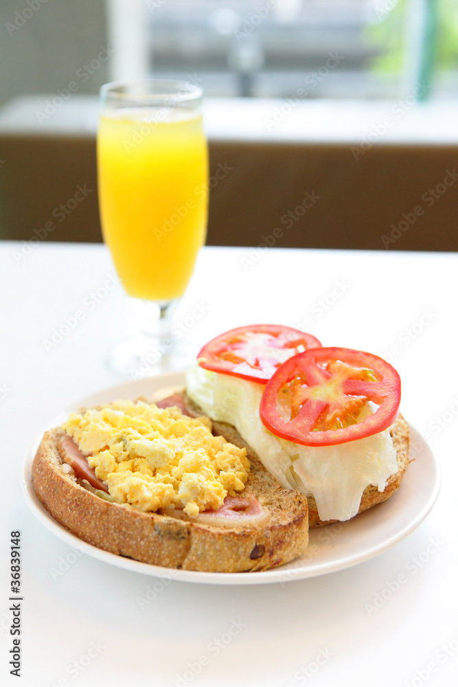 美味的早餐包括鸡蛋、番茄、吐司和橙汁