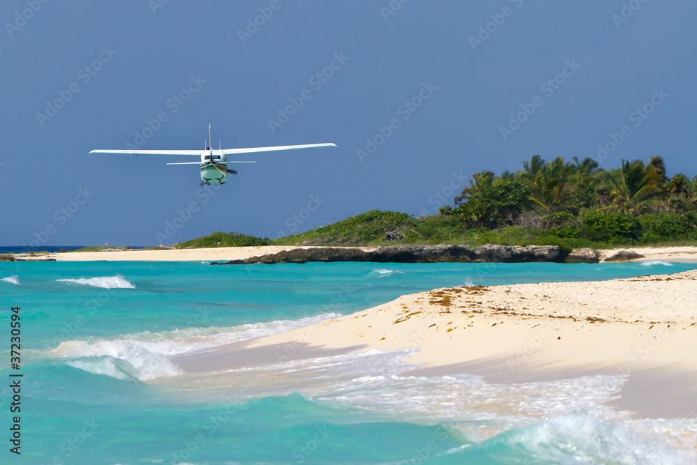 Small tourist plane over Caribbean beach in Mexico
