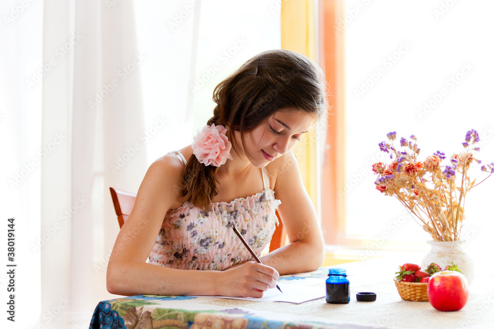 夏日女孩在室内用钢笔和墨水在桌子上写字