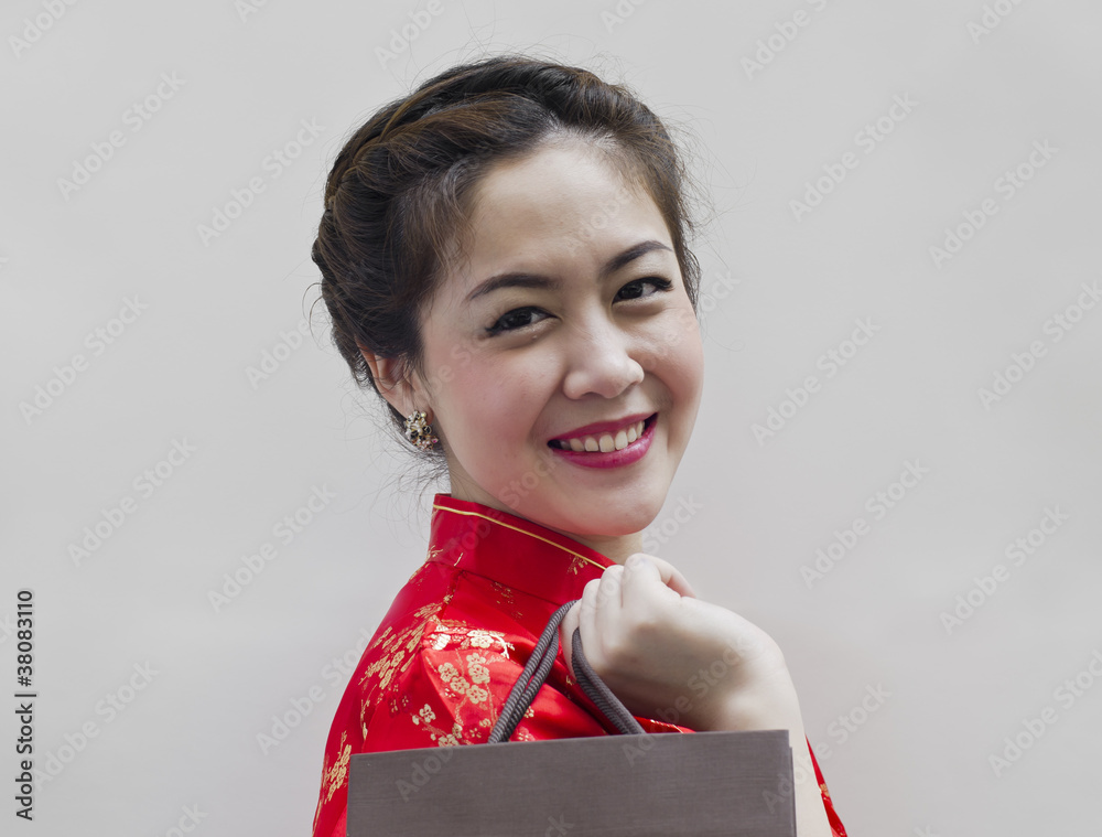 穿着红色中国传统格子衫的女人带着购物袋