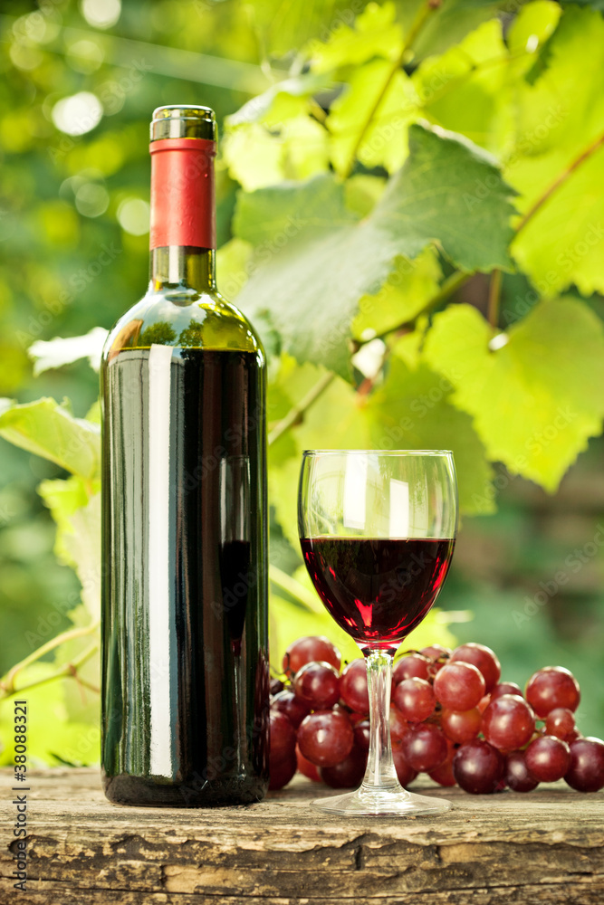红葡萄酒瓶、玻璃杯和一串葡萄