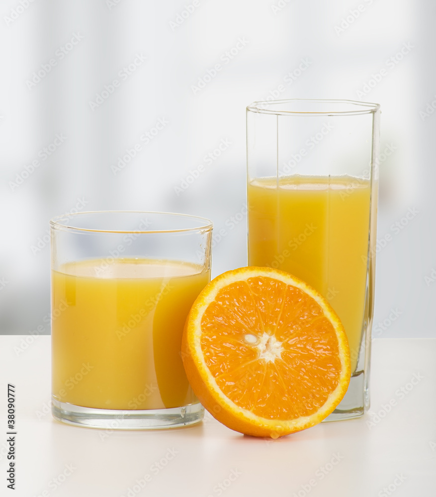 两杯橙汁和切好的熟橙子