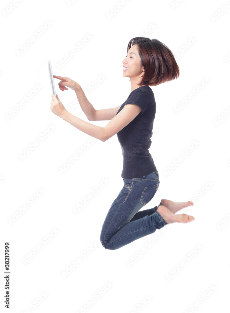 年轻美女快乐跳跃并在空中使用平板电脑