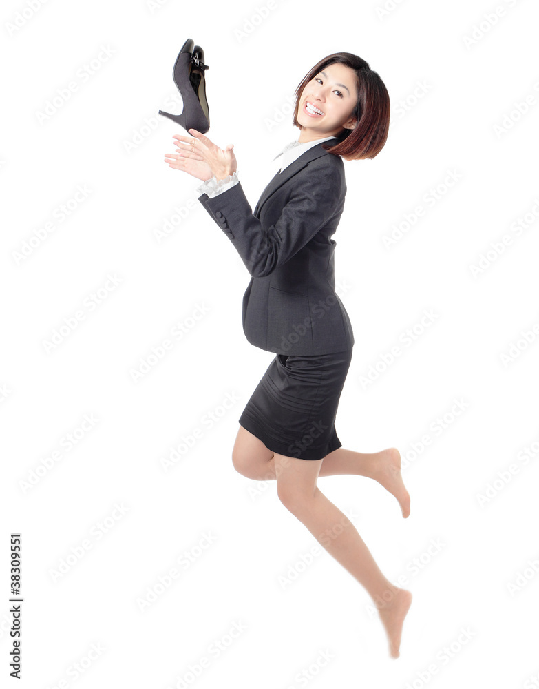 年轻的商业女性快乐地跳起来，把鞋子扔到空中