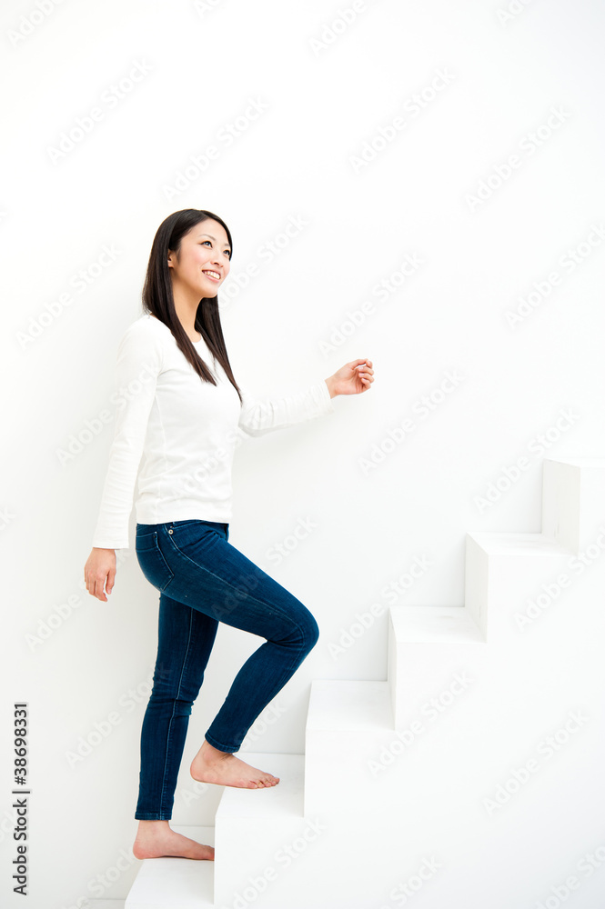 白色房间楼梯上的迷人亚洲女人