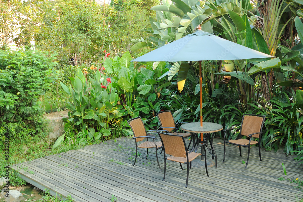 花园家具-藤椅和伞下桌子