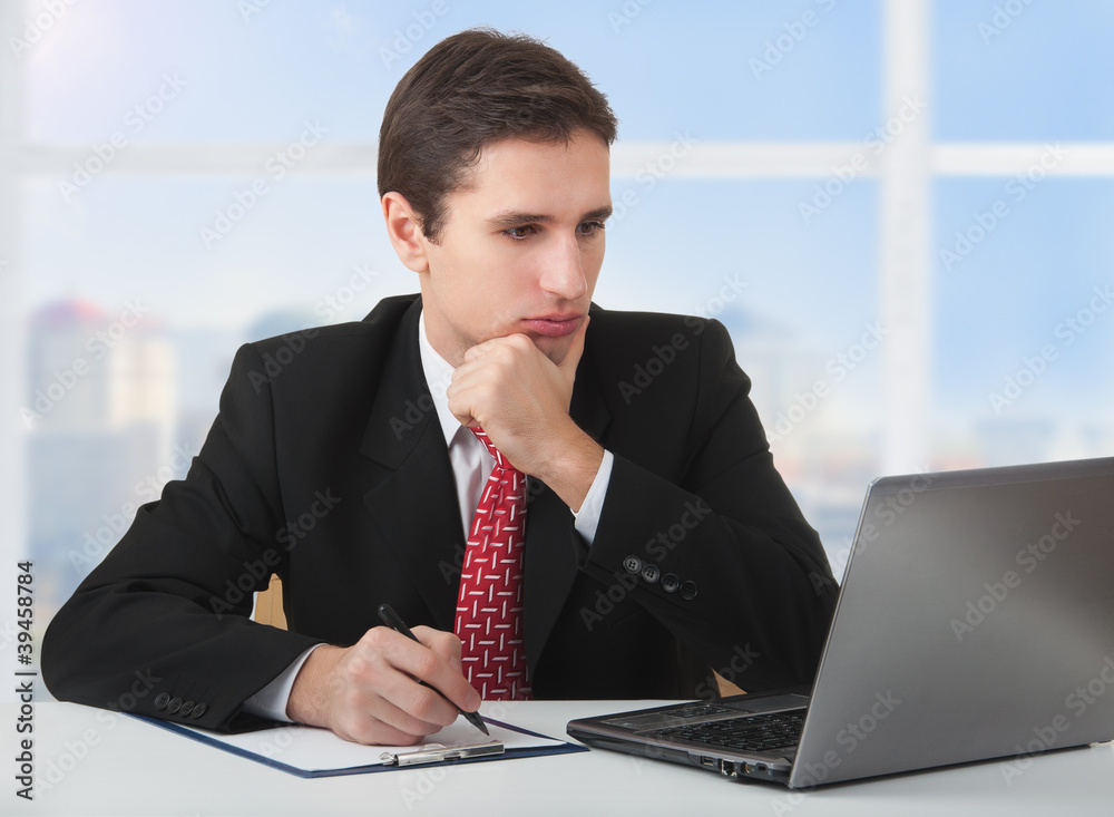 年轻的成功商人，在笔记本电脑后面工作，sitti