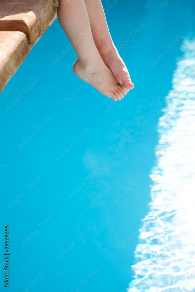 儿童脚踩蓝色游泳池