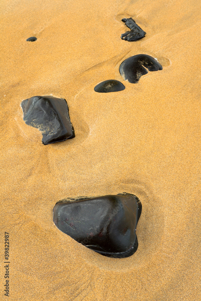 Black stones in sand background