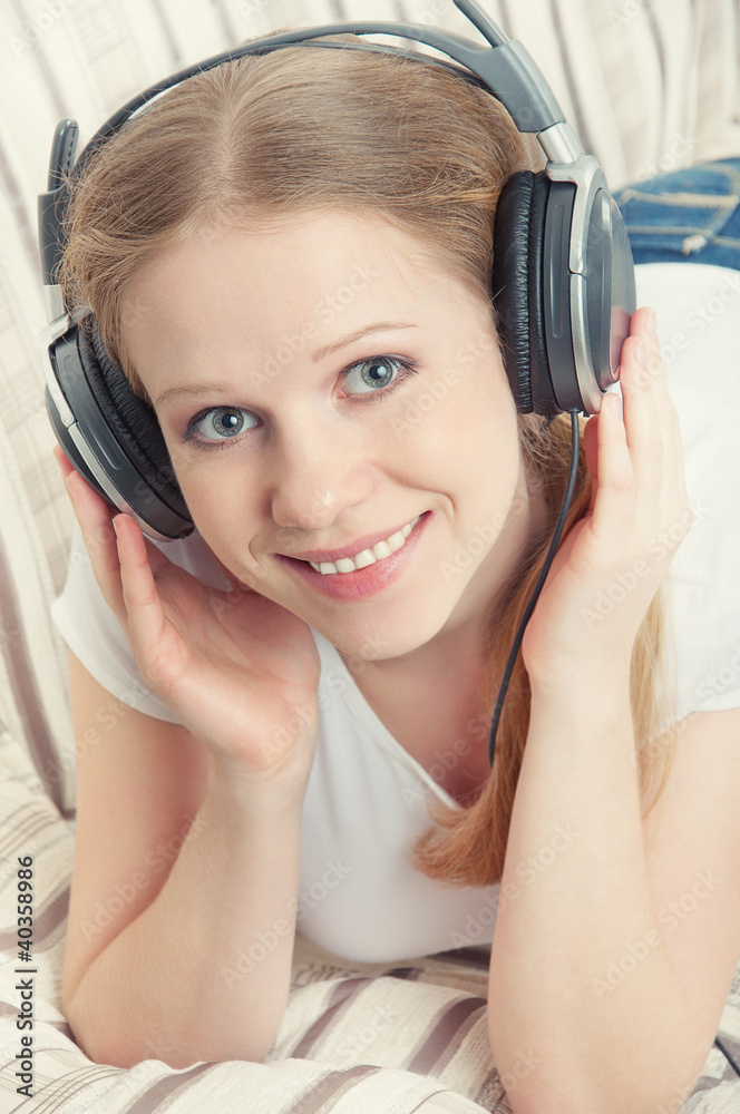 美丽的微笑女孩喜欢用耳机听音乐o