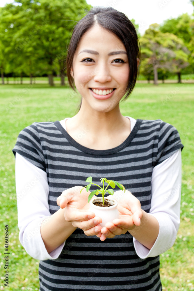 亚洲女人在公园里抱着小植物