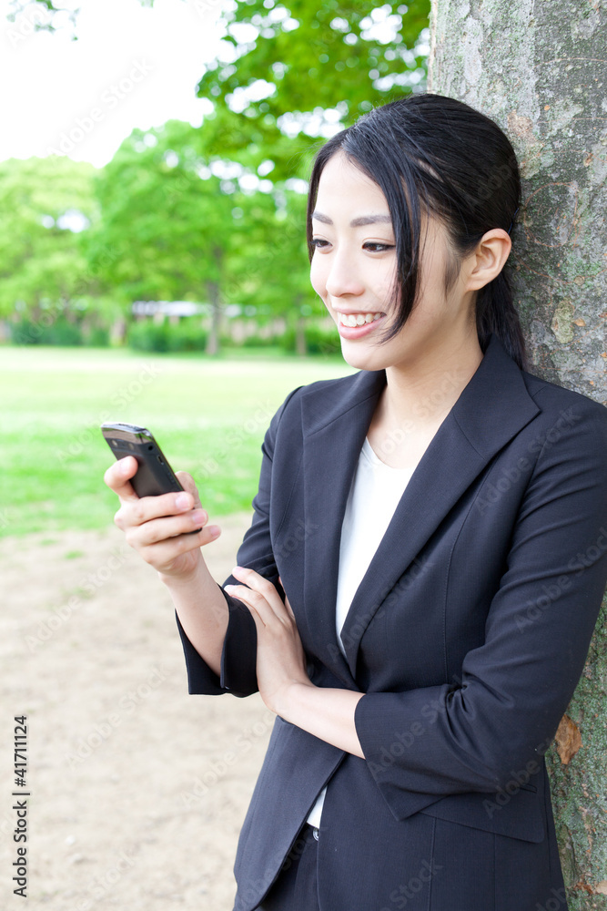 亚洲女商人在公园里使用智能手机