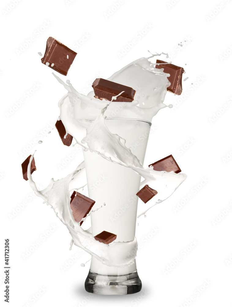 Milk with chocolate bars splashing out of glass