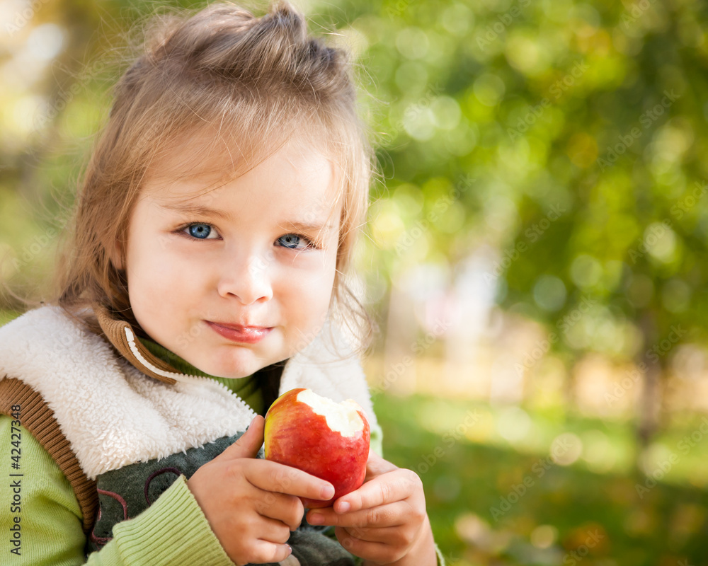 秋天公园里带着苹果的孩子