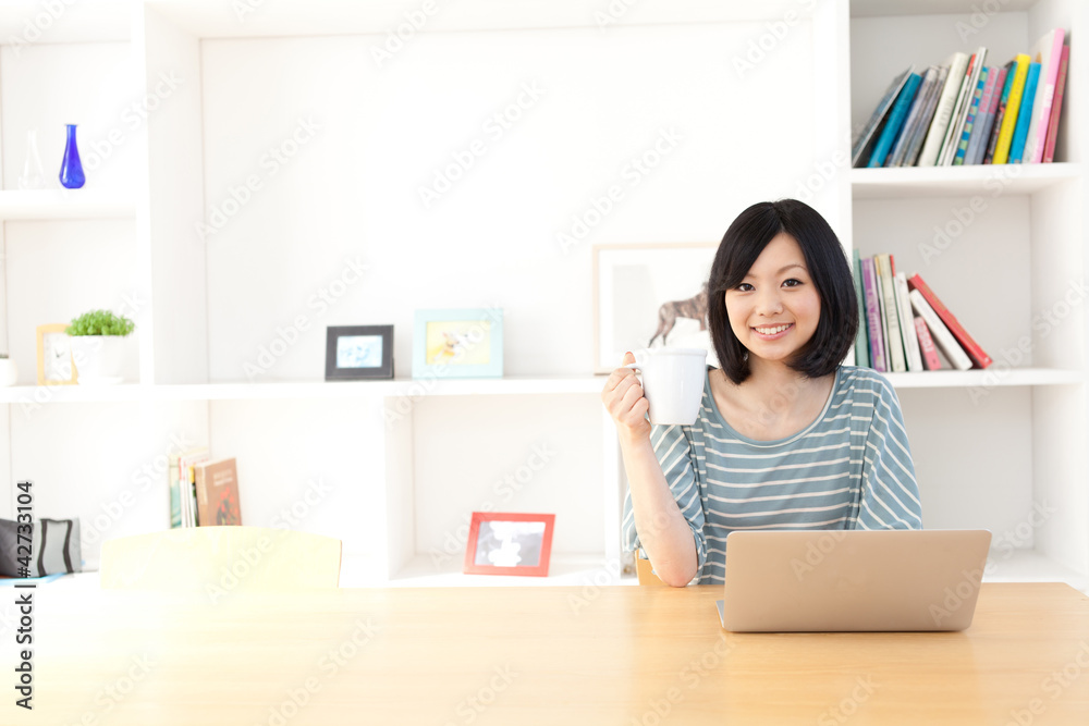一名使用笔记本电脑的年轻亚洲女性
