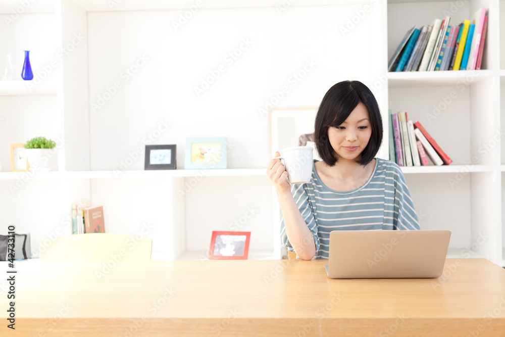 一名使用笔记本电脑的年轻亚洲女性