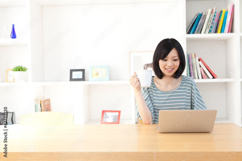一位使用笔记本电脑的年轻亚洲女性